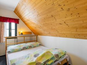 a bed in a room with a wooden ceiling at Holiday Home Holiday Hill 67 by Interhome in Lauterwasser