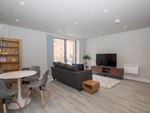 a living room with a couch and a tv and a table at Pass the Keys Superb Central 4 Sleeper Apartment with Parking in Slough