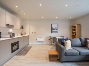 uma sala de estar com um sofá e uma cozinha em Pass the Keys Superb Central 4 Sleeper Apartment with Parking em Slough