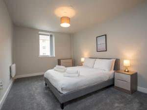 a bedroom with a bed with white sheets and a window at Pass the Keys Superb Central 4 Sleeper Apartment with Parking in Slough