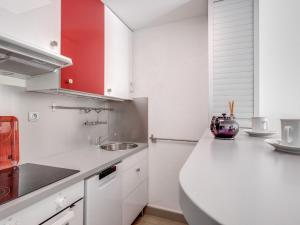 a white kitchen with a sink and a counter at Studio Le Mexico-8 by Interhome in Saint-Raphaël