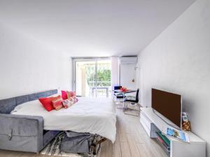 a bedroom with a large bed and a tv at Studio Le Mexico-8 by Interhome in Saint-Raphaël +10 photos