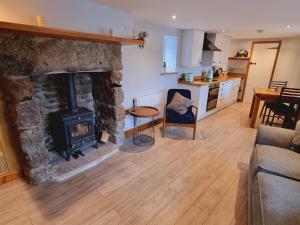 un soggiorno con camino in pietra e una cucina di Pass the Keys Charming 19th century country cottage for 2 guests a Exeter