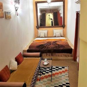 una camera con un grande letto e uno specchio di Dar Narjis a Marrakech