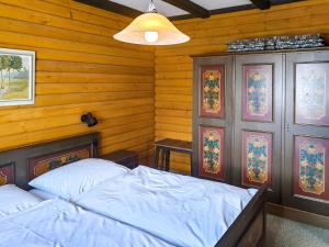 een slaapkamer met een bed in een houten kamer bij Apartment Am Hohen Bogen-39 by Interhome in Arrach