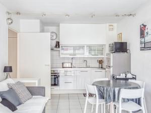 a living room with a table and a kitchen at Apartment Le Cesarée-5 by Interhome in Fréjus