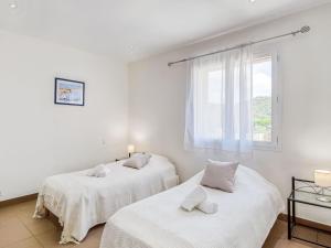 deux lits dans une chambre blanche avec une fenêtre dans l'établissement Holiday Home Villa Belios by Interhome, à Porto-Vecchio 21 autres photos