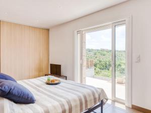 une chambre avec un lit et une grande fenêtre dans l'établissement Holiday Home Villa Belios by Interhome, à Porto-Vecchio