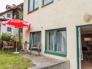 un patio con sedie e ombrellone accanto a un edificio di Apartment Annis Nest by Interhome a Ramsau am Dachstein