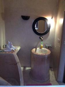 bagno con lavandino e specchio di Dar Narjis a Marrakech