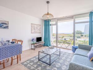 uma sala de estar com um sofá azul e uma mesa em Studio Les Trois Iles-7 by Interhome em Quiberon