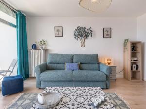 uma sala de estar com um sofá azul e uma mesa em Studio Les Trois Iles-7 by Interhome em Quiberon