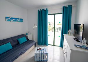 コスタ・テギセにあるSea Breeze Apartment 309のリビングルーム(青いカーテン、ソファ付)