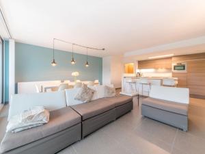 ein Wohnzimmer mit einem großen Sofa und einer Küche in der Unterkunft Apartment Residentie Odyssea I by Interhome in Bredene