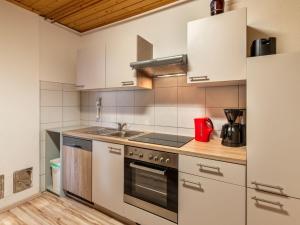 una cocina con armarios blancos y fregadero en Apartment Pistenblick-3 by Interhome, en Hochrindl