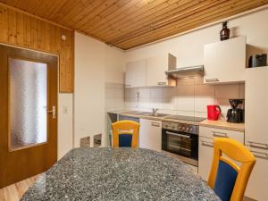 a kitchen with a table and some yellow chairs at Apartment Pistenblick-3 by Interhome in Hochrindl