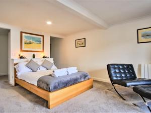 a bedroom with a bed and a black chair at Apartment Imperial Apartment by Interhome in Oban