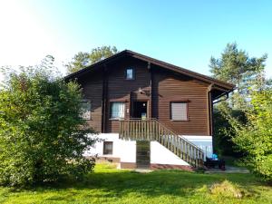 ein großes Holzhaus mit einer Treppe davor in der Unterkunft Apartment Am Hohen Bogen-45 by Interhome in Arrach