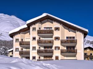 a building with snow on the ground in front of it at Apartment Chesa Arpschellas - Reis by Interhome in Zuoz