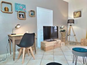 un soggiorno con scrivania e TV di Maison Chic & charme Calme avec Jardin a Le Mans