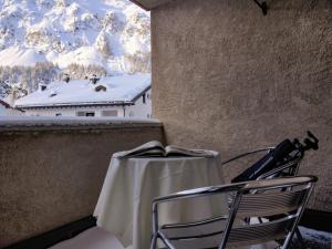 a table and chairs with a view of snow covered mountains at Apartment Chesa Ginellas by Interhome in Sils Maria