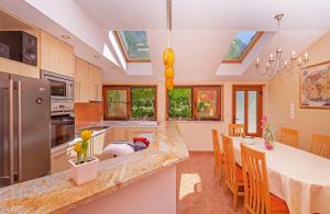 uma cozinha com uma mesa de jantar e uma cozinha com clarabóias em Holiday Home Ana's Paradise em Mlini