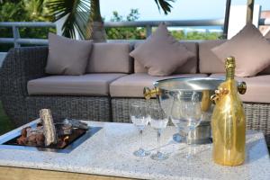 a table with wine glasses and a bottle on it at Kokogrove Chalets in Anse Royale