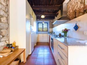 a kitchen with white cabinets and a tile floor at Holiday Home Tio Pepe de Maja by Interhome in Godall +28 photos