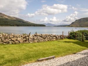a stone wall next to a body of water at Holiday Home Old School by Interhome in Dunan