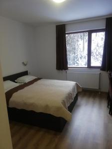 a bedroom with a bed and a large window at семеен хотел Обзор in Progled