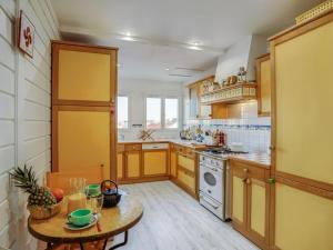 una cocina con armarios de madera y una mesa con comida. en Apartment Les Montgolfières by Interhome en Biarritz