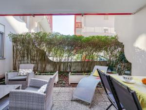 d'une terrasse avec des chaises, des tables et une clôture. dans l'établissement Apartment Bibi Beaurivage by Interhome, à Biarritz