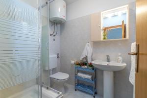 y baño con lavabo, aseo y ducha. en Apartments Grgeta Funtana, en Funtana