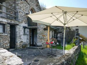 een paraplu op een patio voor een gebouw bij Holiday Home Scateto 66 by Interhome in Malvaglia