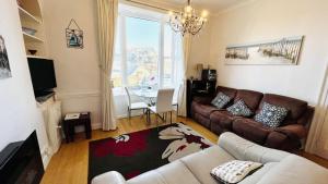 a living room with a couch and a table at 2 Dartview - Close to the Water, River Views, Ground Floor Access in Dartmouth