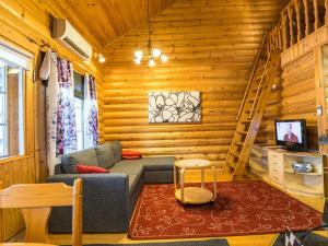 a living room with a couch in a log cabin at Holiday Home Ukkohovi 4 paritalo by Interhome in Hyrynsalmi