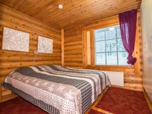 a bedroom with a bed in a log cabin at Holiday Home Ukkohovi 4 paritalo by Interhome in Hyrynsalmi