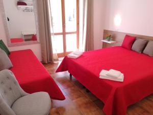 a bedroom with a red bed with a red blanket at Sunway Apartments in Alghero