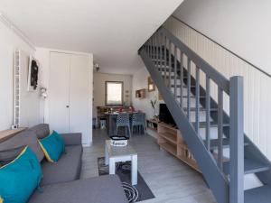 een woonkamer met een bank en een trap bij Holiday Home Les Maisons de la Plage-12 by Interhome in Le Grau-du-Roi