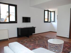 un soggiorno con divano bianco e TV di Apartment Casa Fiorita-2 by Interhome a Brusino Arsizio