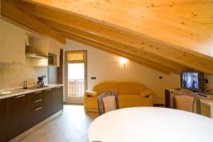 a kitchen and living room with a yellow couch at Chalet Kiara - Appartamenti Abar in Livigno