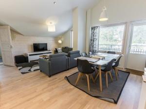 uma sala de estar com uma mesa e cadeiras e uma televisão em Holiday Home Levin stara a10 by Interhome em Sirkka
