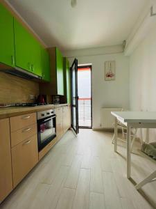 une cuisine avec des placards verts et une table. dans l'établissement Xclusive apartment, à Iaşi