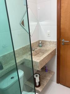 a bathroom with a shower and a sink and a toilet at Pé na areia Fábio e Silvia in Praia Grande