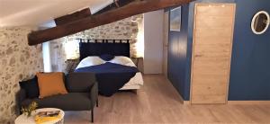 1 dormitorio con 1 cama, 1 sofá y 1 silla en La Maison d'hôtes, en Le Poujol-sur-Orb