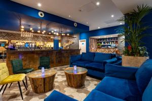 a lobby with blue couches and a bar at Weetwood Hall Estate in Leeds