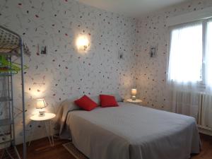 a bedroom with a bed with red pillows on it at chambre d'hôte in Pontorson