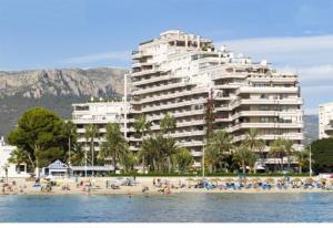 a large building on a beach with people on the beach at Calpe Paraiso Playa primera linea in Calpe