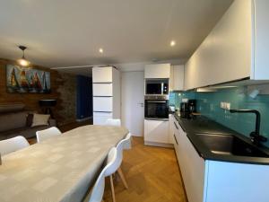 een keuken en een woonkamer met een tafel en stoelen bij Apartment Le point du jour 1 by Interhome in Cancale