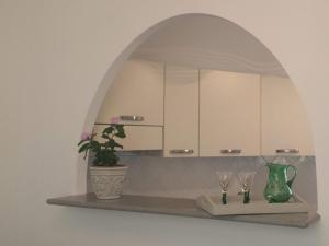 une étagère avec deux verres et une plante en pot dans l'établissement B&B La casa del mugnaio di Capriata d'Orba, à Predosa
